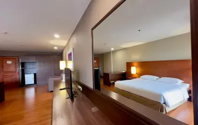a bedroom with a bed and a large mirror at BU Place Hotel in Bangkok
