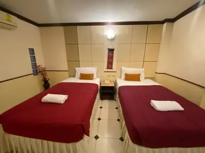 two beds in a small room with red sheets at Honey House 2 in Bangkok