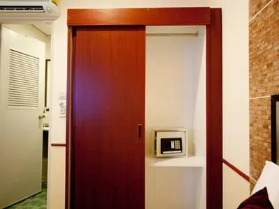 a wooden door in a room with a microwave at Honey House 2 in Bangkok
