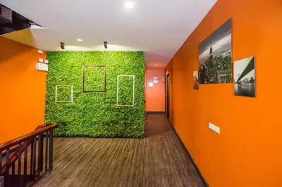 a hallway with a green wall in an office at The Corner Ratchada in Bangkok