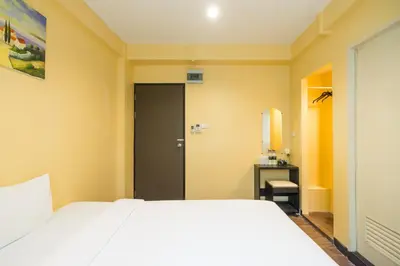 a bedroom with a white bed and a bathroom at The Corner Ratchada in Bangkok