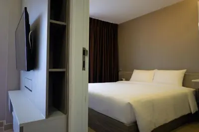 a bedroom with a bed and a flat screen tv at 18 Residence in Bangkok