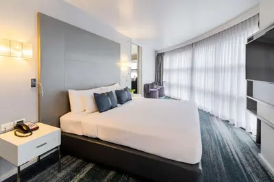 a bedroom with a large white bed and a large window at Best Western Sukhumvit 20 in Bangkok