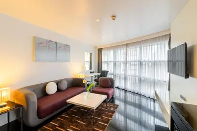 a living room with a couch and a tv at Best Western Sukhumvit 20 in Bangkok