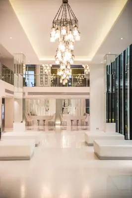 a large lobby with white furniture and a chandelier at Bangkok Midtown Hotel in Bangkok