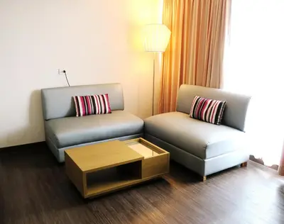 a living room with two chairs and a coffee table at Samran Place Hotel in Bangkok