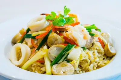 a bowl of food with shrimp and vegetables on rice at Samran Place Hotel in Bangkok