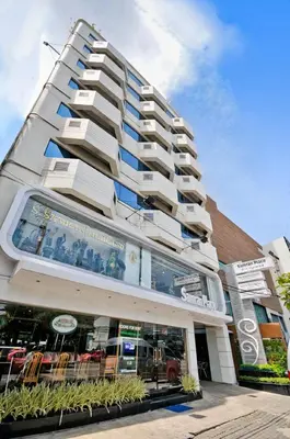 a tall apartment building with a store front at Samran Place Hotel in Bangkok