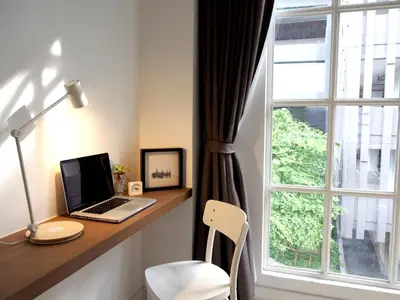 a laptop computer sitting on a desk next to a window at Varmtel in Bangkok