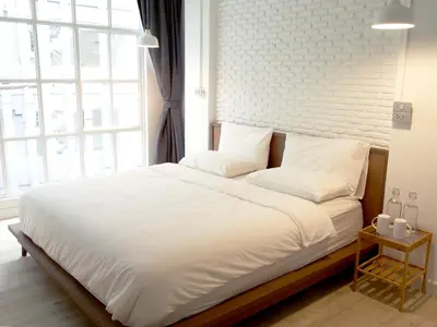 a bedroom with a large bed with a brick wall at Varmtel in Bangkok