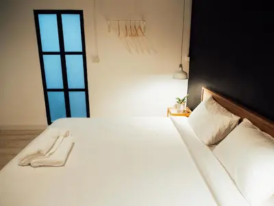 a bedroom with a bed with white sheets and pillows at Varmtel in Bangkok