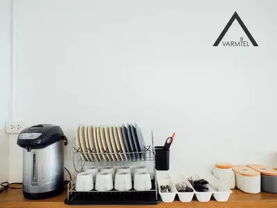 a counter top with a coffee maker and some cups at Varmtel in Bangkok