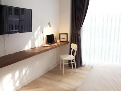 a bedroom with a desk with a computer and a chair at Varmtel in Bangkok