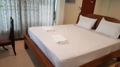 a bedroom with a bed with two towels on it at Samsen Sam Place in Bangkok