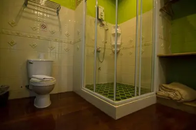 a bathroom with a shower and a toilet at Samsen Sam Place in Bangkok
