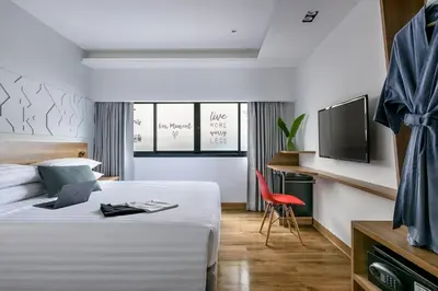 a hotel room with a bed and a television at VELA be Bangkok Ratchathewi in Bangkok