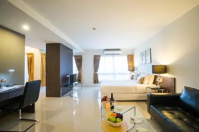 a large living room with a bed and a couch at Beyond Suite in Bangkok