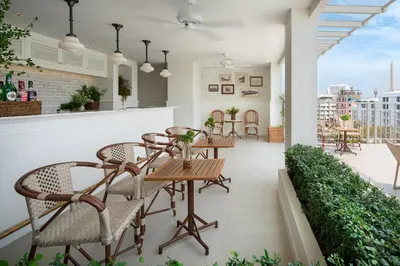 a restaurant with chairs and tables on a balcony at Casa Vimaya Riverside in Bangkok