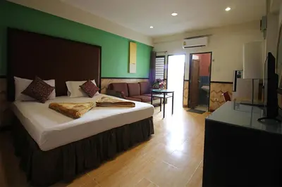 a bedroom with a bed and a living room at Kaya Place in Bangkok