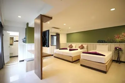 a living room with two beds and a television at Kaya Place in Bangkok
