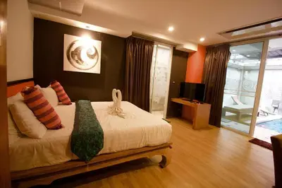 a bedroom with a bed and a television in it at Eurna Resort Hotel in Bangkok