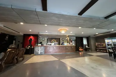 a restaurant with a counter and chairs in a room at Eurna Resort Hotel in Bangkok