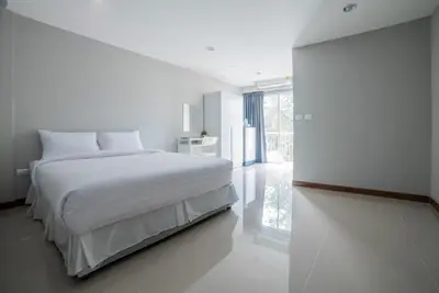 a white bedroom with a bed and a window at S44ROOM in Bangkok