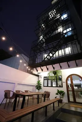 a patio with a table and chairs and a building at Apartment45 Hostel in Bangkok