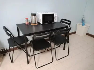a black table with chairs and a microwave on it at Nesto Condo at Muangthong in Pak Kret