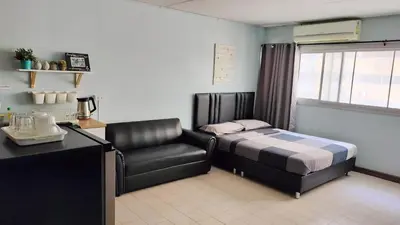 a bedroom with a bed and a chair in it at Nesto Condo at Muangthong in Pak Kret