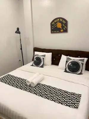 a bed with black and white sheets and pillows at 101 SEOUL HOSTEL (101 โซล โฮสเทล) in Bangkok
