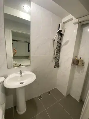 a white bathroom with a sink and a mirror at 101 SEOUL HOSTEL (101 โซล โฮสเทล) in Bangkok