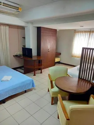 a hotel room with a bed and a table and chairs at Mansion Sarasinee @ Chatuchak in Bangkok
