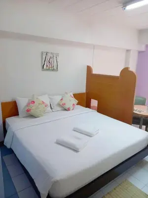 a bedroom with a white bed with towels on it at Mansion Sarasinee @ Chatuchak in Bangkok