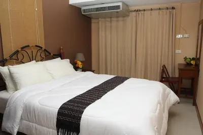 a bedroom with a white bed with a black and white blanket at PR Place Hotel in Bangkok