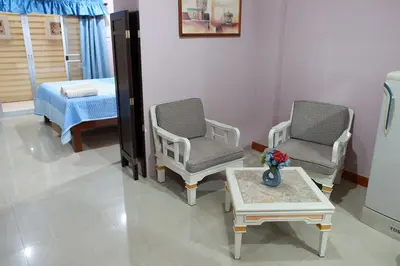 a room with two chairs and a table and a bed at PR Place Hotel in Bangkok