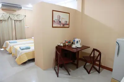a bedroom with a table and a bed and a table and chairs at PR Place Hotel in Bangkok