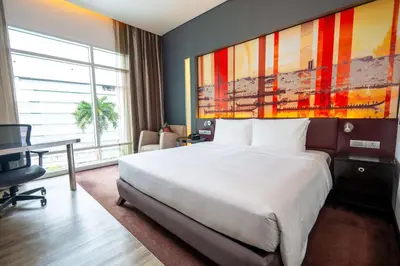 a hotel room with a large bed and a desk at Park Plaza Bangkok Soi 18 in Bangkok
