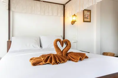 a towel in the shape of a heart sitting on a bed at SK Boutique Mahanakhon in Bangkok