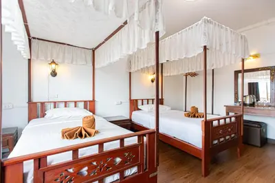 two beds in a bedroom with white curtains at SK Boutique Mahanakhon in Bangkok