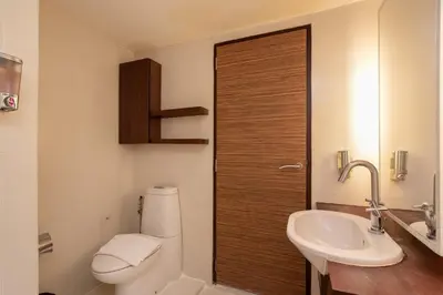 a bathroom with a toilet and a sink at Veronica Residence in Bangkok