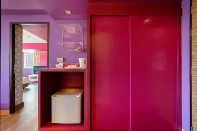 a red cabinet in a room with purple walls at Veronica Residence in Bangkok