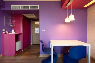 a dining room with purple walls and a table and chairs at Veronica Residence in Bangkok