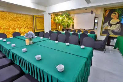 a conference room with a green table and chairs at Diamond City Hotel SHA Certified in Bangkok