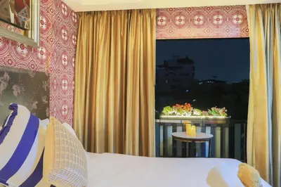 a bedroom with a bed and a window with a table at Diamond City Hotel SHA Certified in Bangkok