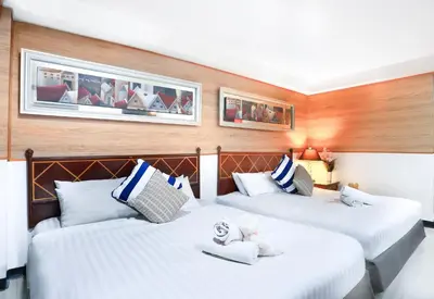 two beds in a room with wooden walls at Diamond City Hotel SHA Certified in Bangkok