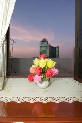 a vase filled with flowers sitting on a table at Poonchock Mansion in Bangkok