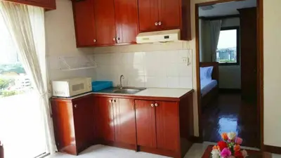a small kitchen with a sink and a microwave at Poonchock Mansion in Bangkok