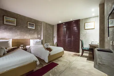 a hotel room with two beds and a desk at Buddy Boutique Inn in Bangkok