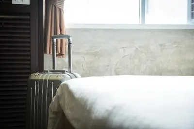 a hotel room with a suitcase next to a bed at Buddy Boutique Inn in Bangkok